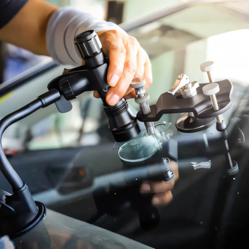 A stone chip repair tool in use on a windscreen